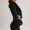 Tuta Corte con corsetto e bordi in pelliccia sintetica Nesta in nero Tuta Corte con corsetto e bordi in pelliccia sintetica Nesta in nero