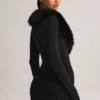 Tuta Corte con corsetto e bordi in pelliccia sintetica Nesta in nero Tuta Corte con corsetto e bordi in pelliccia sintetica Nesta in nero