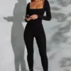 Tuta Delanie a maniche lunghe con scollo quadrato in nero Tuta Delanie a maniche lunghe con scollo quadrato in nero