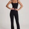 Tuta Elanie con scollo rotondo, corpetto a corsetto e pantaloni svasati in nero Tuta Elanie con scollo rotondo, corpetto a corsetto e pantaloni svasati in nero