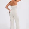 Tuta intera a fascia con pantaloni svasati in maglia grossa color crema Tuta intera a fascia con pantaloni svasati in maglia grossa color crema