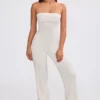 Tuta intera a fascia con pantaloni svasati in maglia grossa color crema Tuta intera a fascia con pantaloni svasati in maglia grossa color crema