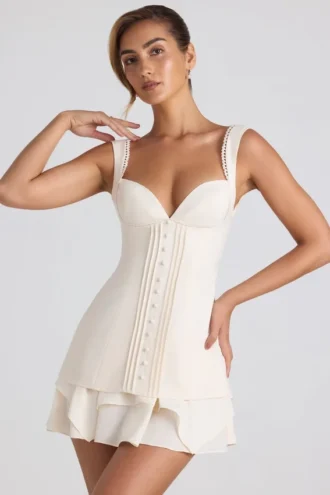 Vestito corto a corsetto con volant e bottoni Cassandra in avorio