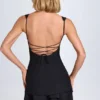Vestito corto a corsetto con volant e bottoni Cassandra in nero Vestito corto a corsetto con volant e bottoni Cassandra in nero