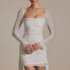 Vestito corto drappeggiato con collo a cappuccio e decorazioni Marilla in bianco Vestito corto drappeggiato con collo a cappuccio e decorazioni Marilla in bianco
