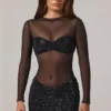 Vestito corto Noel trasparente con decorazioni, collo alto e maniche lunghe in nero Vestito corto Noel trasparente con decorazioni, collo alto e maniche lunghe in nero