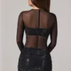 Vestito corto Noel trasparente con decorazioni, collo alto e maniche lunghe in nero Vestito corto Noel trasparente con decorazioni, collo alto e maniche lunghe in nero