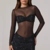 Vestito corto Noel trasparente con decorazioni, collo alto e maniche lunghe in nero Vestito corto Noel trasparente con decorazioni, collo alto e maniche lunghe in nero