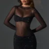 Vestito corto Noel trasparente con decorazioni, collo alto e maniche lunghe in nero Vestito corto Noel trasparente con decorazioni, collo alto e maniche lunghe in nero