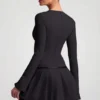 Vestito corto plissettato a maniche lunghe Fiorella in nero Vestito corto plissettato a maniche lunghe Fiorella in nero