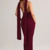 Vestito lungo con scollo all’americana e dettagli a sciarpa in maglia a coste Dree, color vino Vestito lungo con scollo all’americana e dettagli a sciarpa in maglia a coste Dree, color vino
