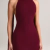 Vestito lungo con scollo all’americana e dettagli a sciarpa in maglia a coste Dree, color vino Vestito lungo con scollo all’americana e dettagli a sciarpa in maglia a coste Dree, color vino
